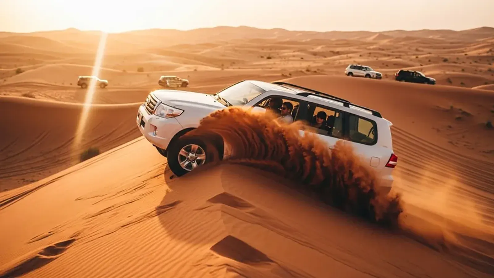 White Toyota Land Cruiser carving a turn down a red dune on an evening desert safari